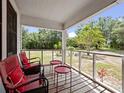 Relaxing porch with outdoor seating, offering views of the expansive front yard and mature trees at 485 Palm St, Winter Garden, FL 34787