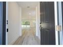 View from the front door into a bright, open-concept living space with sleek gray flooring at 509 St. Johns Ct, Poinciana, FL 34759