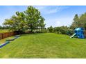 Spacious backyard features lush lawn, mature trees, play area, perfect for Gathering fun and outdoor entertaining at 5384 Barton Dr, Orlando, FL 32807