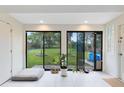 Bright sun room with large windows overlooking the spacious backyard complete with lush greenery and a playset at 5384 Barton Dr, Orlando, FL 32807