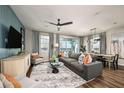 Comfortable living room featuring a gray sofa, stylish decor, and views of the outdoors through large windows at 564 Southern Edge Way, Sanford, FL 32771