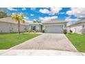 Inviting single-story home features a brick driveway, lush lawn, and fresh landscaping under a partly cloudy sky at 6013 Mount Zion Cir, Deland, FL 32724