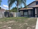 View of front yard with palm tree and the side of the house with a window at 6554 Meritmoor Cir, Orlando, FL 32818