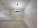 Living room with white walls, and an elegant ceiling light fixture at 6554 Meritmoor Cir, Orlando, FL 32818