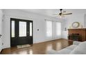 Bright living room boasts hardwood floors, brick fireplace, and an ornate glass and metal front door at 708 S Laurel Ave, Sanford, FL 32771