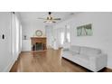 Bright living room featuring hardwood floors, white sofa, and a classic brick fireplace at 708 S Laurel Ave, Sanford, FL 32771
