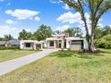 Striking modern home showcases clean lines, stone accents, and a manicured lawn under a blue sky at 7615 Se 12Th Cir, Ocala, FL 34480