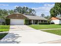 Brick ranch home with attached garage and concrete driveway, complemented by lush green lawn at 7618 Majestic Pine Ct, Orlando, FL 32819