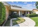 Inviting front porch with brick accents, plants, and a winding walkway through landscaped yard at 7618 Majestic Pine Ct, Orlando, FL 32819