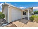 Attached one-car garage with a concrete driveway and manicured landscaping at 8443 Sw 109Th Pl, Ocala, FL 34481