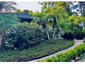 Beautiful landscaping featuring lush greenery and palm trees enhances the curb appeal of this home at 98 Wisteria Dr, Longwood, FL 32779