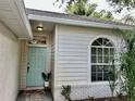 Inviting home entrance with a blue door, decorative window and pleasant landscaping at 11725 Cuxham Dr, Orlando, FL 32837