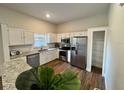 Modern kitchen features stainless steel appliances, granite countertops, and wood-look floors at 11725 Cuxham Dr, Orlando, FL 32837