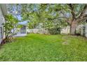 Expansive backyard featuring lush green grass, mature trees, and a charming white picket fence at 1181 Welch Hill Cir, Apopka, FL 32712
