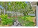 Landscaped backyard featuring lush lawn, mature trees, flower beds, and a charming fish pond at 1181 Welch Hill Cir, Apopka, FL 32712
