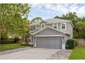 Gray two-story home with a two-car garage, green lawn, and landscaping at 1245 Reagans Reserve Blvd, Apopka, FL 32712