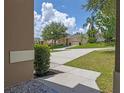 Open view from front door with a sunny driveway and mature landscaping at 12824 Cloverdale Ln, Clermont, FL 34711