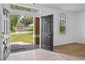 Inviting foyer with an open front door and wood-look flooring and neutral paint at 12824 Cloverdale Ln, Clermont, FL 34711