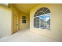 Covered front porch featuring an arched window, and a door at 130 Club Villas Ln, Kissimmee, FL 34744
