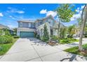 Charming two-story home with a well-manicured lawn, teal garage door, and welcoming front porch at 13822 Darchance Rd, Windermere, FL 34786
