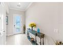 Bright foyer with decorative table, white floors, and an exterior door at 15049 Canopy Cover Dr, Winter Garden, FL 34787