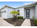 Inviting front entrance with lush landscaping, walkway, and a modern glass front door at 15049 Canopy Cover Dr, Winter Garden, FL 34787