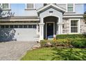 Inviting home entrance with well-manicured landscaping and a paver driveway at 1520 Mulligan Blvd, Davenport, FL 33896