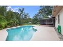 Inviting in-ground pool with a spacious patio and screened enclosure at 1525 Jaguar Cir, Apopka, FL 32712