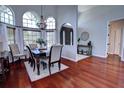 Dining room with wood floors and a high ceiling includes large windows and an elegant chandelier at 1676 Bear Crossing Cir, Apopka, FL 32703