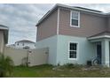 Side exterior view of the house with fence, green grass and bike at 268 Fiddlewood Ct, Davenport, FL 33837