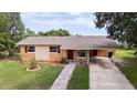 Charming single-story home featuring a well-manicured lawn, complemented by a brick walkway and a convenient carport at 331 Greens End St, Orlando, FL 32810