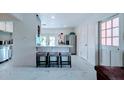 Bright, open kitchen featuring white cabinets, modern appliances, a breakfast bar and a tiled floor at 331 Greens End St, Orlando, FL 32810