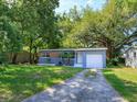 Charming single-story home with mature trees and a well-maintained front yard at 3524 Amigos Ave, Orlando, FL 32808