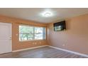 Inviting living room featuring wood-look floors, ample natural light, and modern ceiling light at 3524 Amigos Ave, Orlando, FL 32808