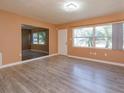 Bright living room with wood-look floors, natural light, and entry door at 3524 Amigos Ave, Orlando, FL 32808
