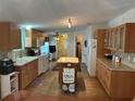 Traditional kitchen with tile backsplash, island, and wood cabinets providing lots of storage at 361 Dreama Dr, Davenport, FL 33897