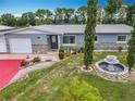 Charming one-story home featuring a well-manicured front yard, fountain, and stone accents at 4021 Queen Anne Dr, Orlando, FL 32839