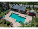 Aerial view of a fenced pool area with lounge chairs and a restroom building at 4528 Commander Dr # 2033, Orlando, FL 32822