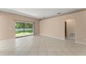 Bright living room featuring neutral walls, tile floors, and a sliding glass door to the backyard at 476 Basking Ridge Ct, Ocoee, FL 34761