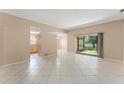Bright, spacious living room with neutral walls and large, light-colored tile flooring throughout at 476 Basking Ridge Ct, Ocoee, FL 34761