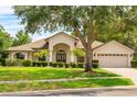 Charming home featuring a well-manicured lawn, mature trees, and attractive landscaping at 4905 Emilee Grace Ln, St Cloud, FL 34771