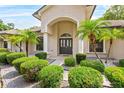 Elegant entryway showcasing a double-door entrance with lush landscaping and manicured shrubs at 4905 Emilee Grace Ln, St Cloud, FL 34771