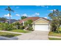 Beautifully landscaped single-story home with lush green lawn and a two car garage at 529 Quail Down Dr, Debary, FL 32713
