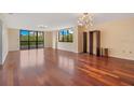 An open living room with hardwood floors, many windows, and decorative lighting fixtures at 530 E Central Blvd # 406, Orlando, FL 32801