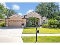 Charming single-Gathering home featuring a manicured lawn, mature trees, and a two-car garage at 533 Pickfair Ter, Lake Mary, FL 32746