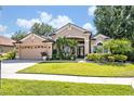 Charming single-Gathering home featuring a manicured lawn, mature trees, and a two-car garage at 533 Pickfair Ter, Lake Mary, FL 32746