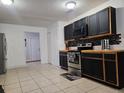 Beautiful kitchen equipped with stainless steel appliances, black cabinets, and a modern tile backsplash at 558 Tyler Ave, Deltona, FL 32725