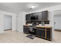 Updated kitchen featuring dark cabinets, sleek appliances, and tile flooring at 558 Tyler Ave, Deltona, FL 32725