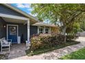 Charming front porch with brick flooring, bench seating, and a welcoming blue front door at 704 Tangerine Ct, Winter Garden, FL 34787