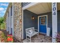 Inviting front porch with stone accents, a blue door, and comfortable bench seating at 704 Tangerine Ct, Winter Garden, FL 34787